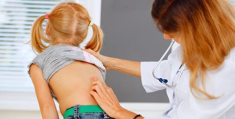 médecin examinant le dos d'un enfant pour des douleurs lombaires